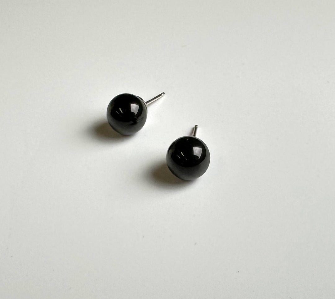 Glossy black jade ball stud earrings with silver posts on a white background