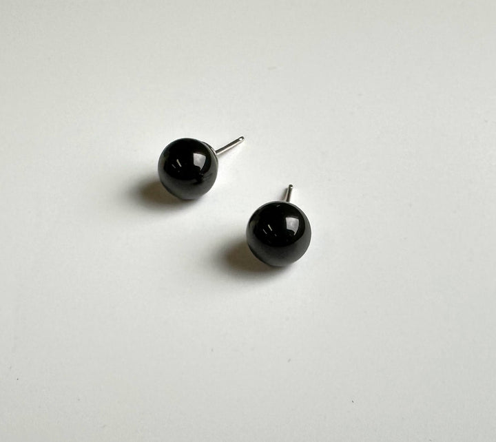 Glossy black jade ball stud earrings with silver posts on a white background