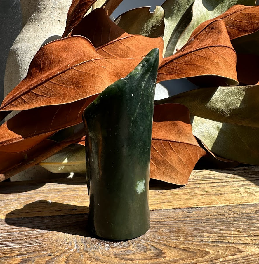 Dark green jade pen holder vase 4 inches displayed on wood with brown leaves in the background