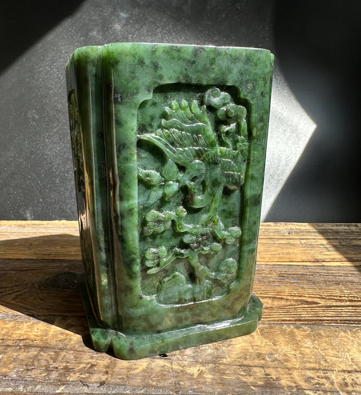 River Jade Vase-Pen Holder placed on wood with sunlight highlighting the jade carving