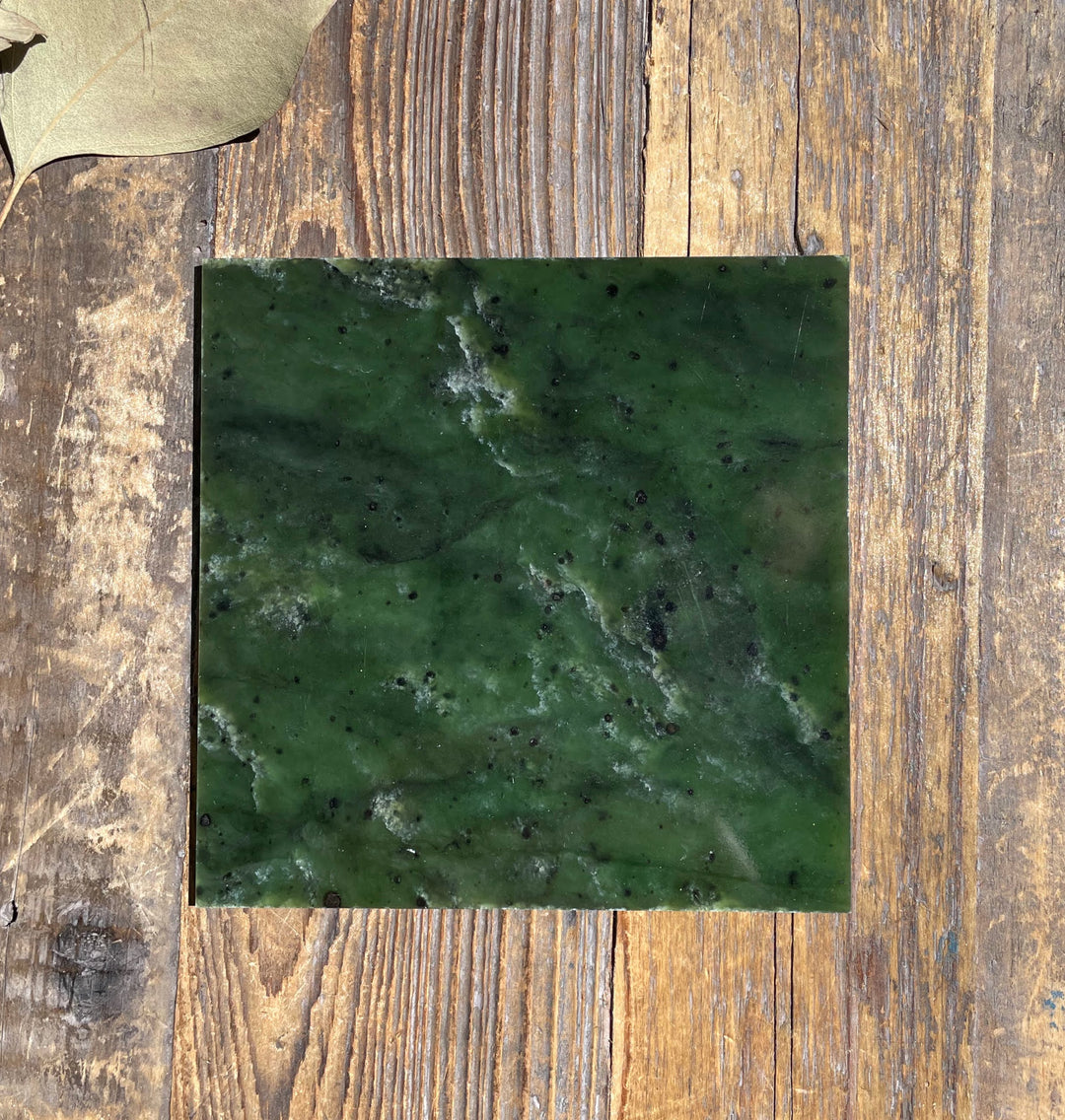 Single 4x4 Canadian Jade tile in dark green with white veining and black speckles.