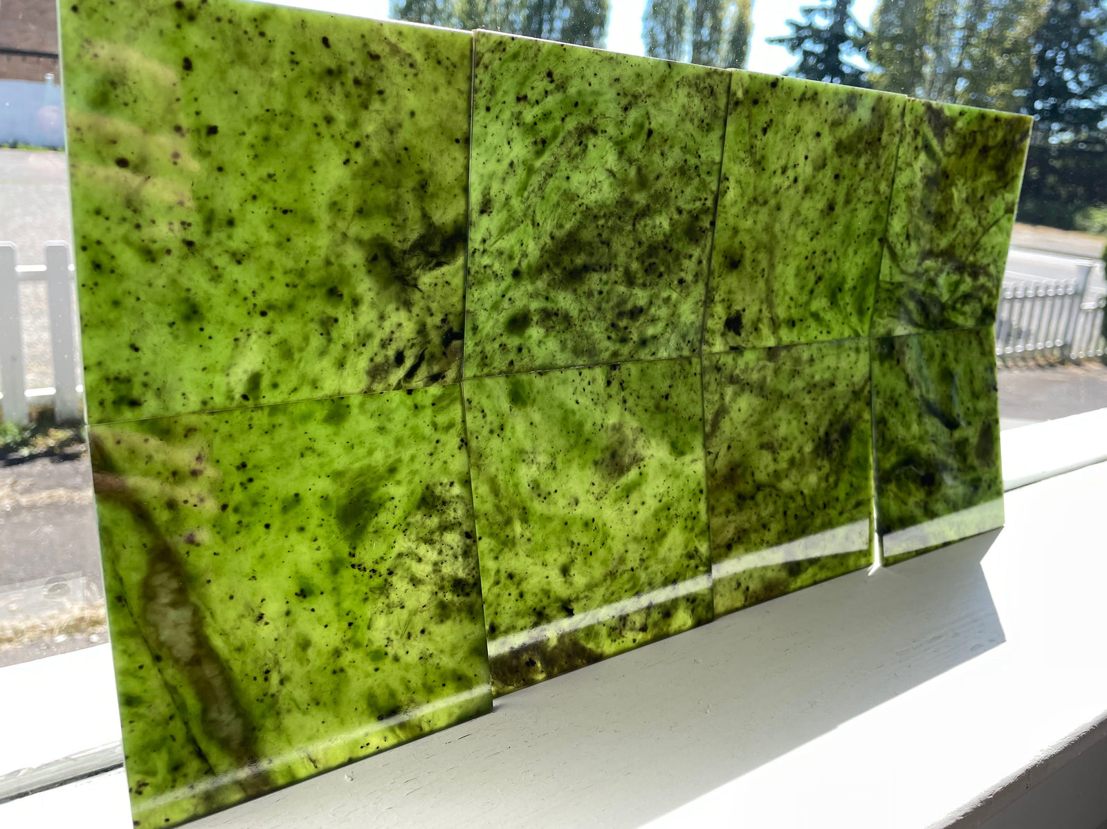 Canadian jade tiles in vivid green with dark speckles arranged as a tiled panel