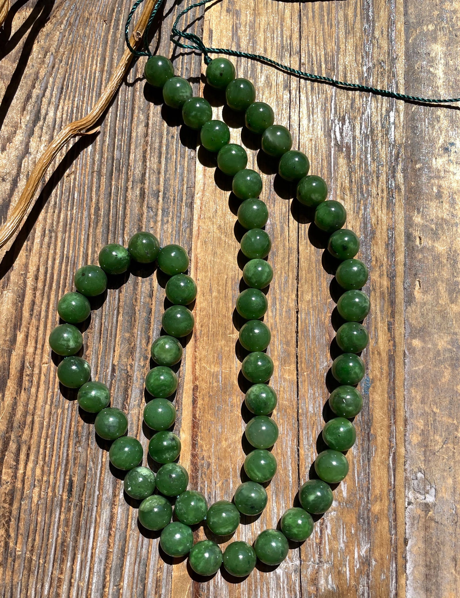 Unstrung 18-inch strand of 8mm carving grade green jade beads with green cord