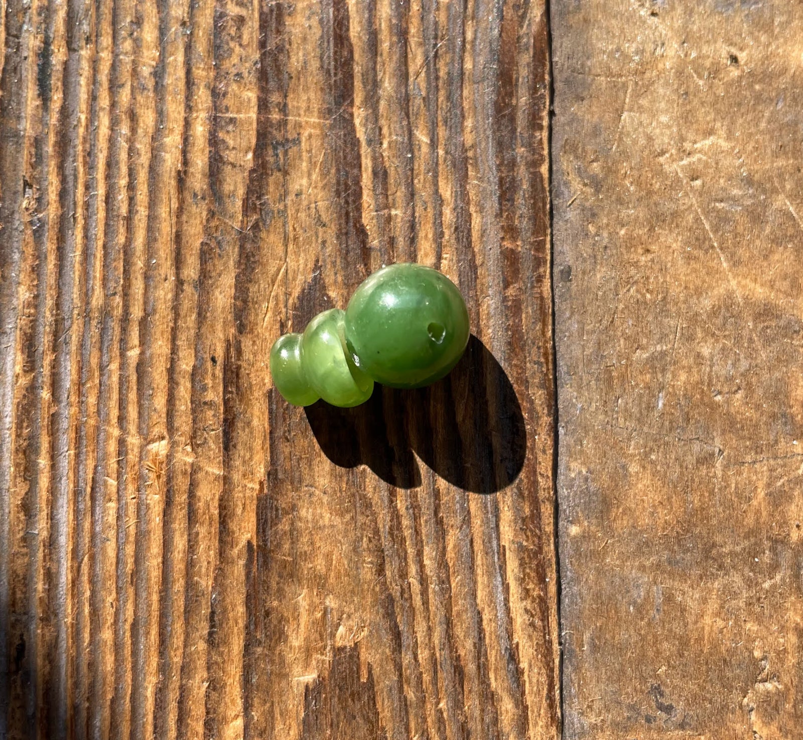 Bright green 10mm Canadian jade guru bead with a single hole for stringing