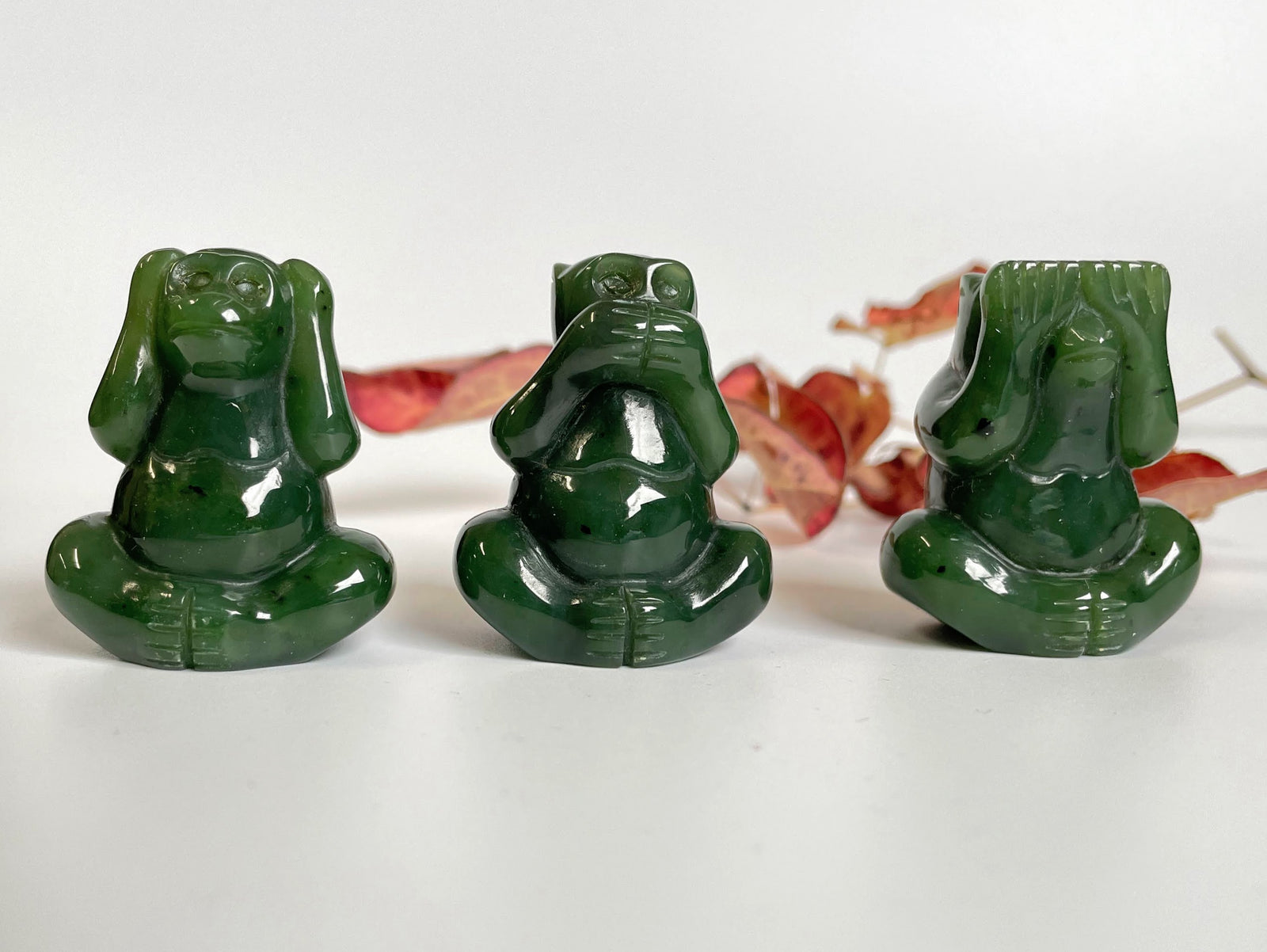 Three green jade monkeys in hear no evil see no evil speak no evil poses.