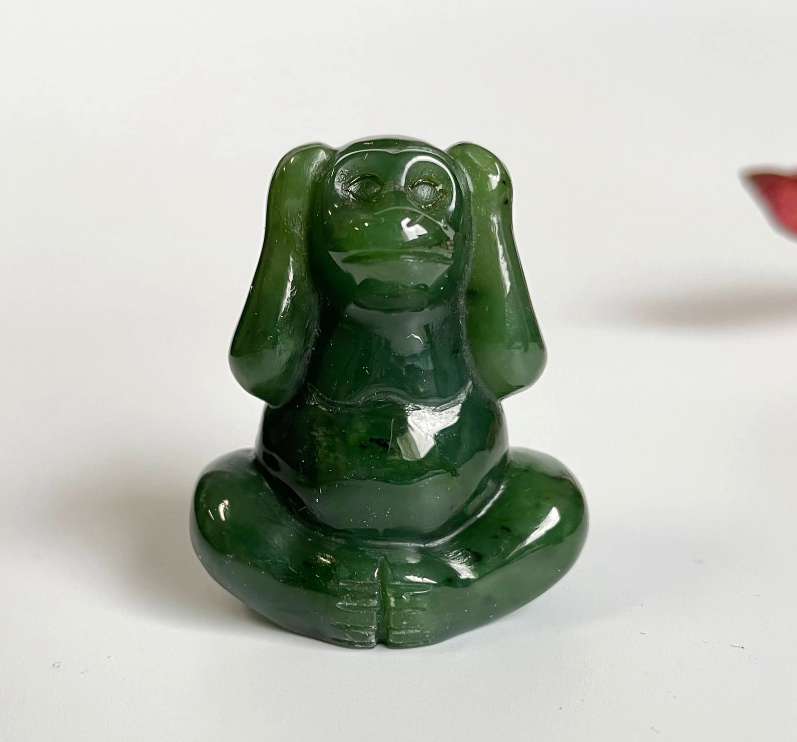 Jade monkey sculpture seated cross legged with a glossy deep green finish