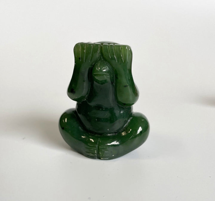 Front close up of jade monkey head with carved hair in glossy green jade