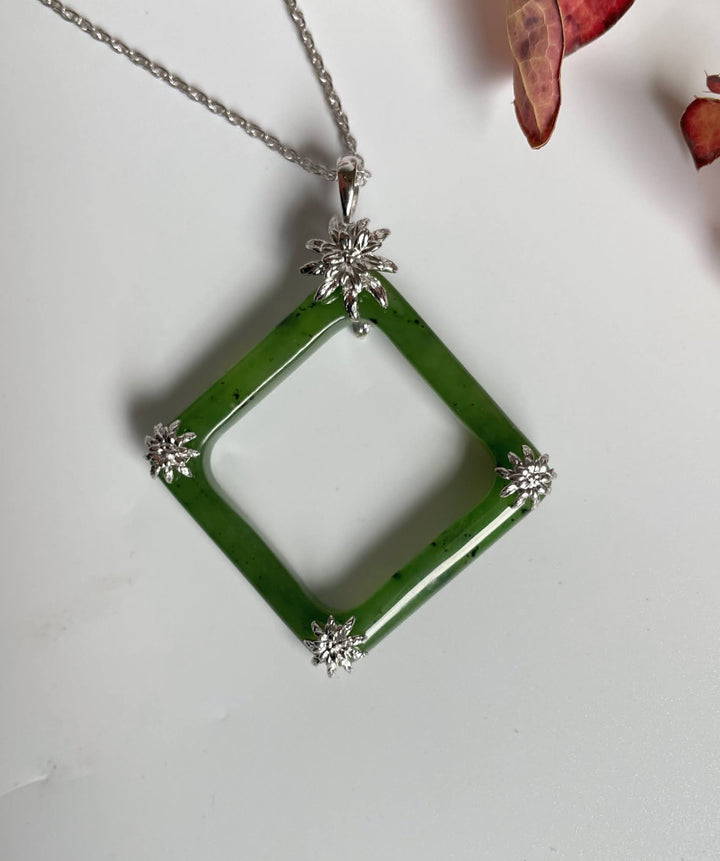 Green jade square pendant with four silver flower end caps on a silver chain