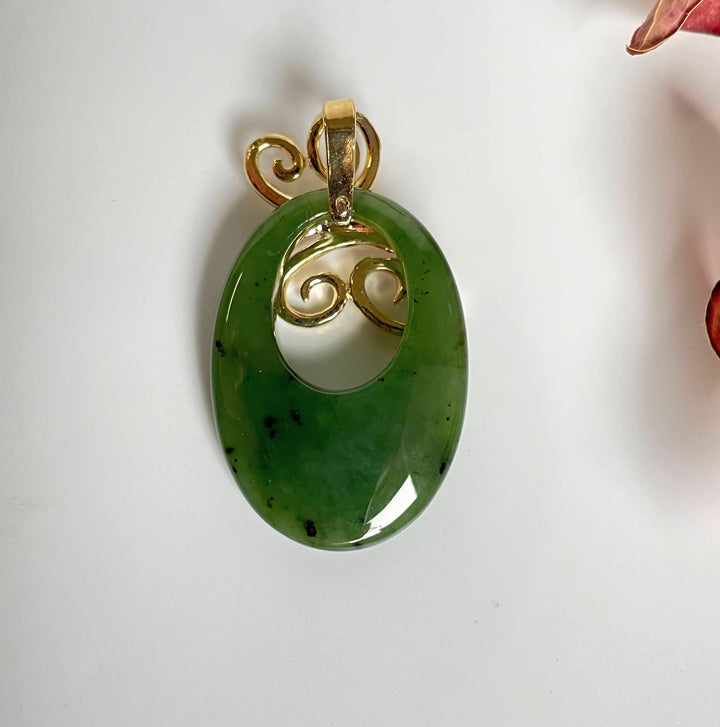 Jade Butterfly Pendant with green oval jade and gold butterfly motif inside a circular opening