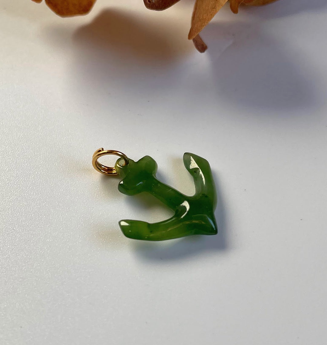 Green jade anchor charm with a gold loop attachment.