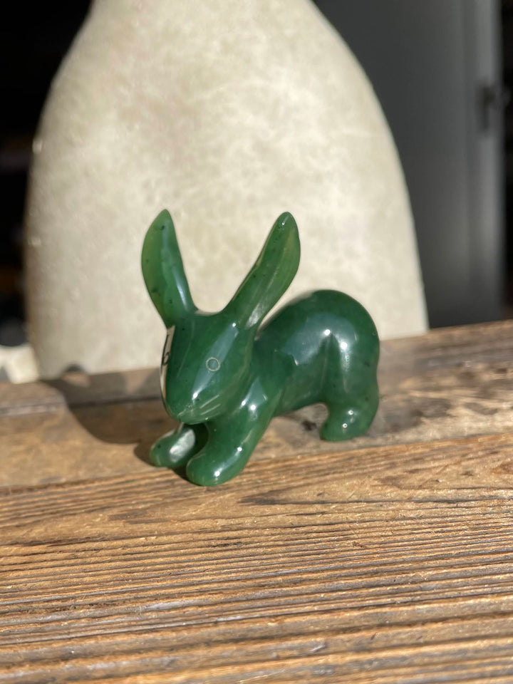 Green jack rabbit sculpture placed on a weathered wooden surface