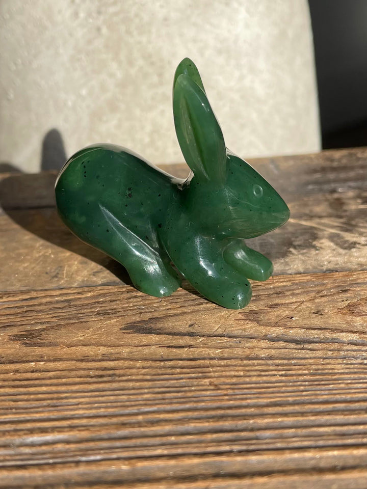 Close up side view of the green jack rabbit carving on a wooden table