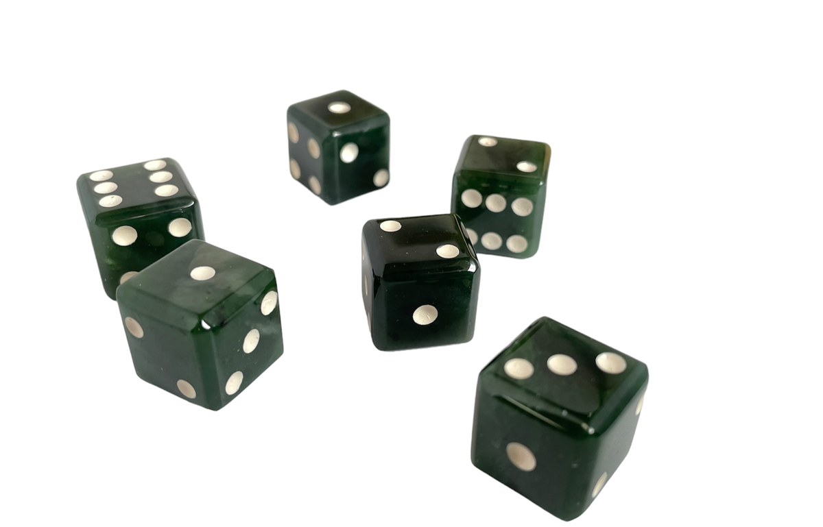 Group of six dark green dice with white pips scattered on a white background