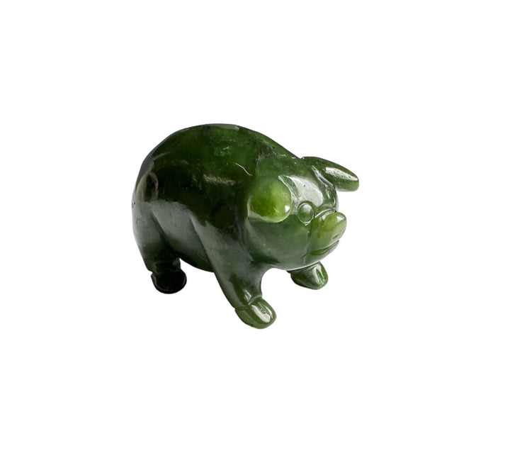 Green jade pig figurine carved from emerald jade on a white background