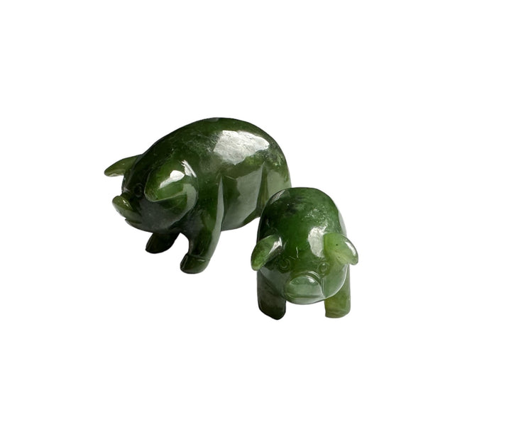 Two green jade pig sculptures in varying sizes
