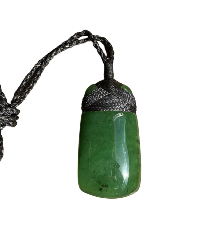 Green jade pendant 2040-1 suspended from a black braided cord against a white background