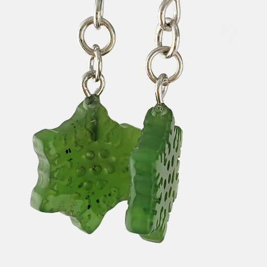 Close up of translucent green jade snowflake charms on silver connectors