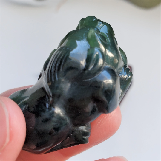 Side profile of dark green jade Pi Xiu pendant 44mm showing carved details.