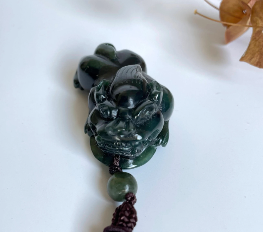 Dark green jade Pi Xiu pendant 44mm on a purple cord with a green bead.