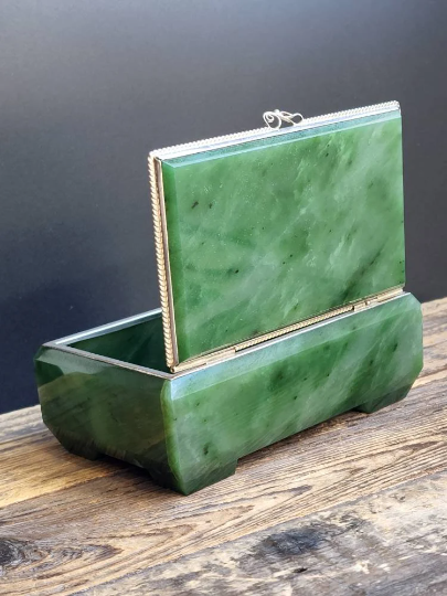 Siberian jade box with silver trim and lid standing upright on a dark background.