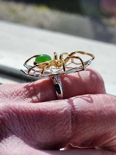 Close up of AA Spider Jade Ring on finger showing the gold spiderweb detail and green jade stone