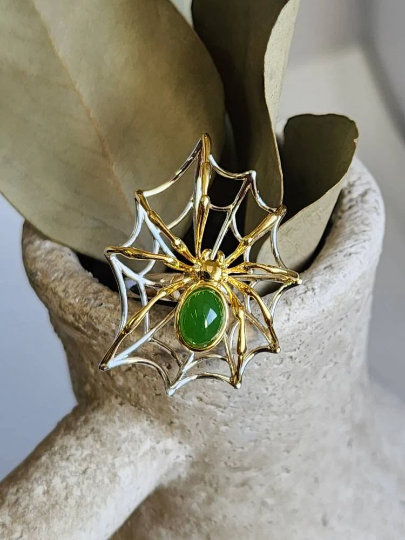 AA Spider Jade Ring in sterling silver resting on a textured clay planter with a jade cabochon