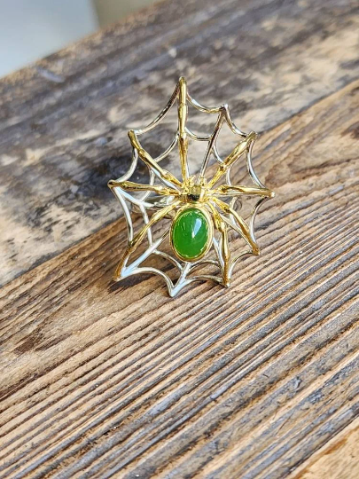 AA Spider Jade Ring with green jade centerpiece in a gold and silver spiderweb setting.