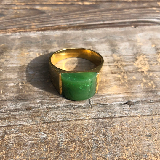 Jade Ring 0364 with a rectangular green jade centerpiece set in a gold band on rustic wood surface