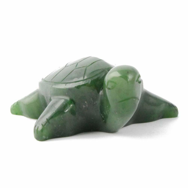 Side view of a green jade turtle figurine with a patterned shell on a white backdrop