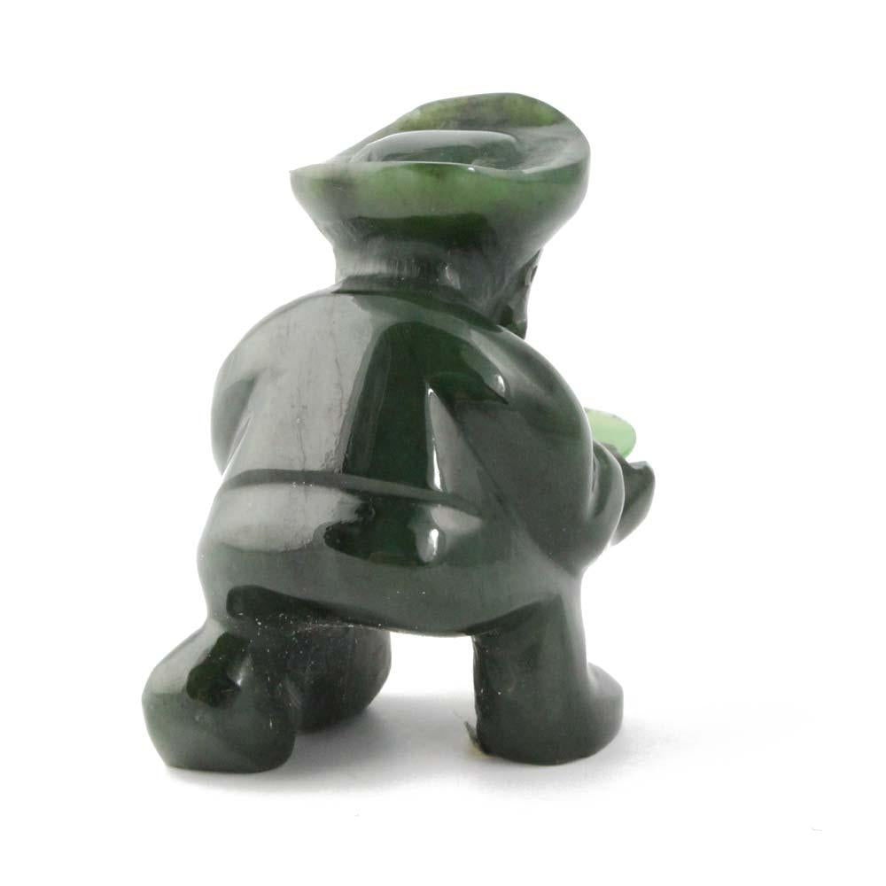 Back view of the green stone gold panner figurine kneeling with pan in front.