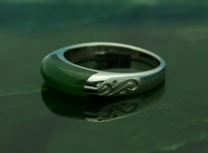 Ring R0392 silver band with green enamel arc and a decorative swirl on the side, shown on a reflective surface.