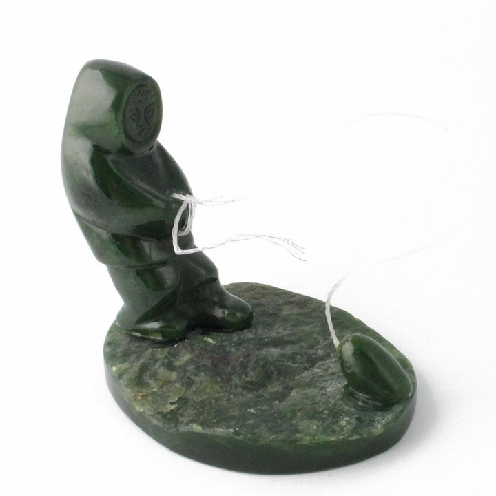 Canadian nephrite jade fisherman catching seal sculpture on a round base