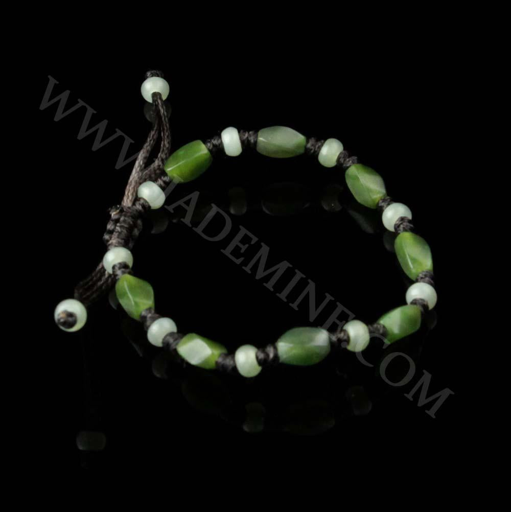 Green and pale green bead bracelet on dark cord with knotted spacers against a black background.
