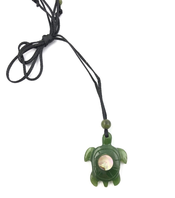 Jade turtle pendant with abalone shell centerpiece on a black cord necklace