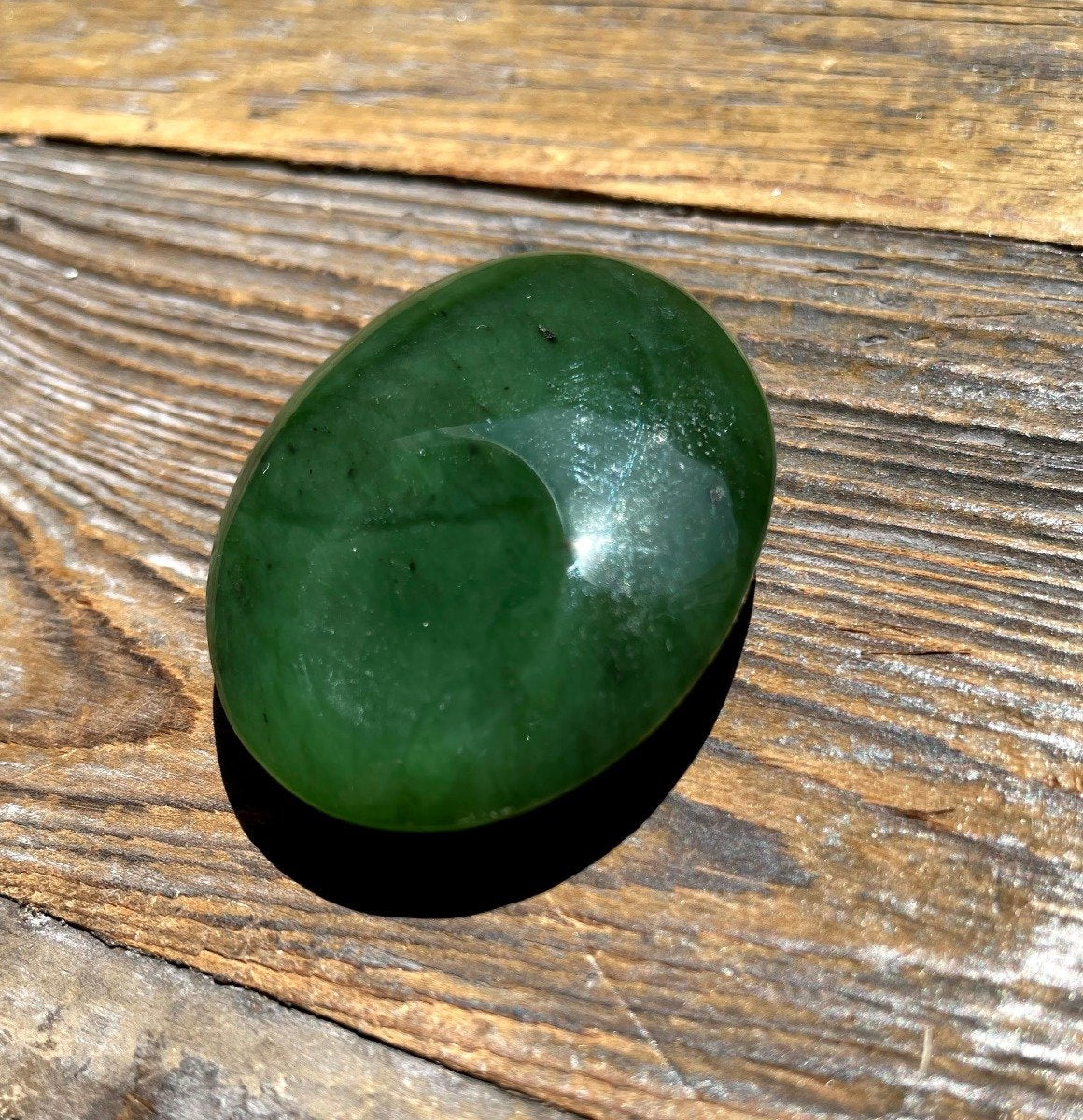 Green jade Oval Worry stone on a wooden base