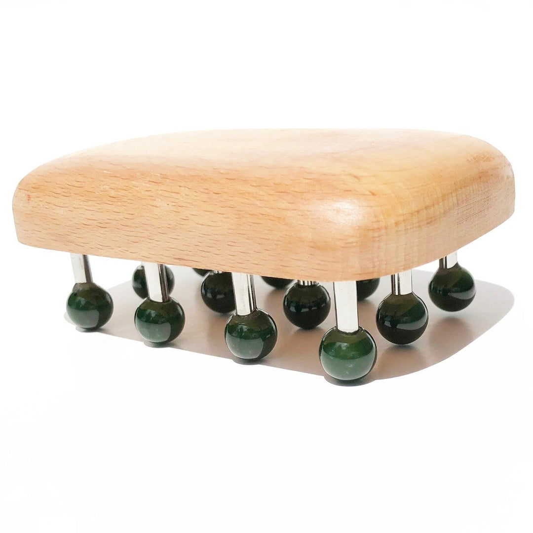 Side view of massage tool showing green knob heads on metal pegs over a rounded wooden base
