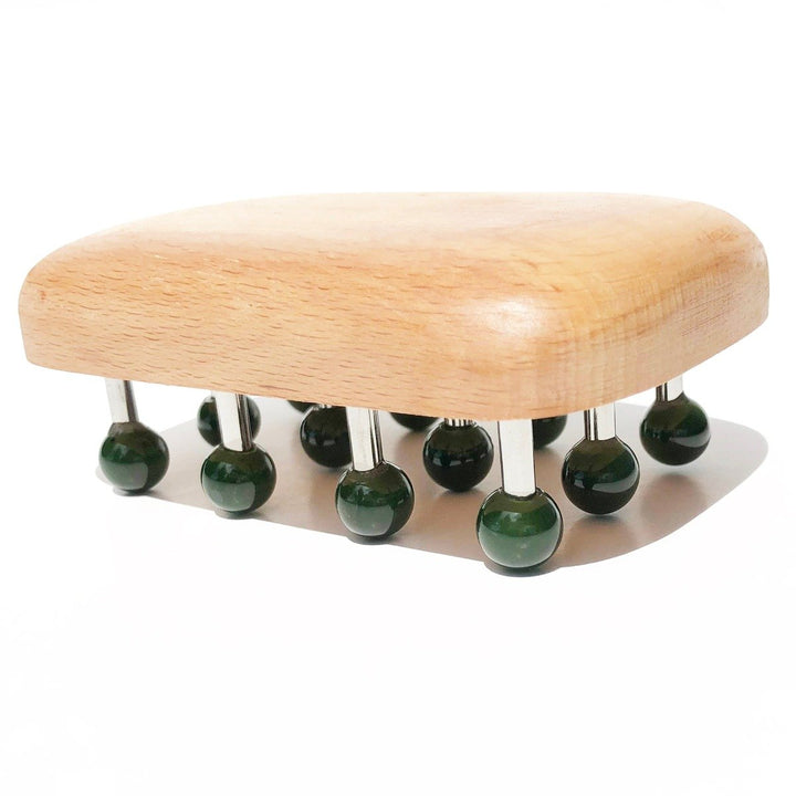 Side view of massage tool showing green knob heads on metal pegs over a rounded wooden base