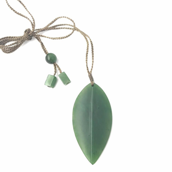 Leaf shaped jade pendant on a braided cord with green beads
