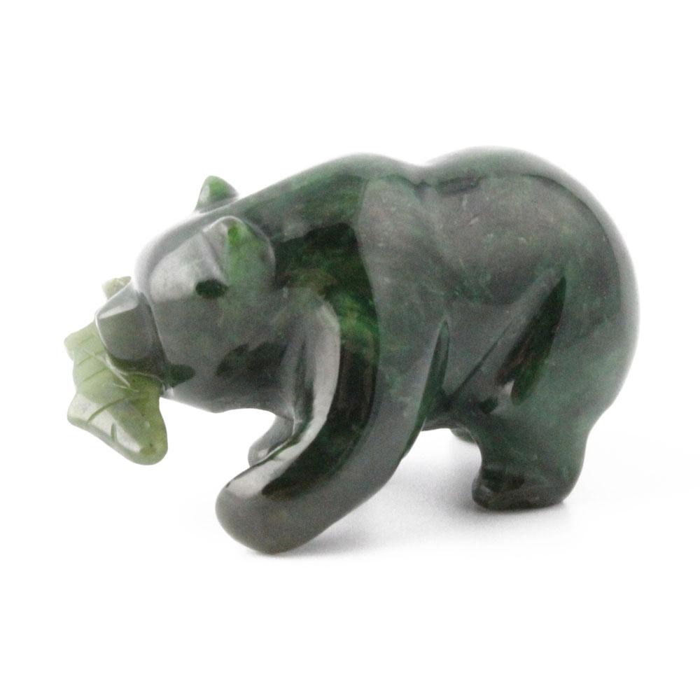 Side view of a dark green grizzly bear figurine with an open mouth and fish