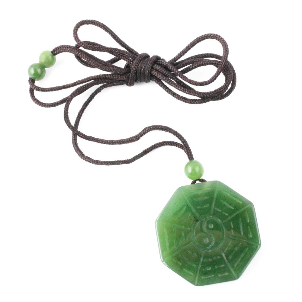 Green octagonal pendant on a brown cord necklace with a small green bead