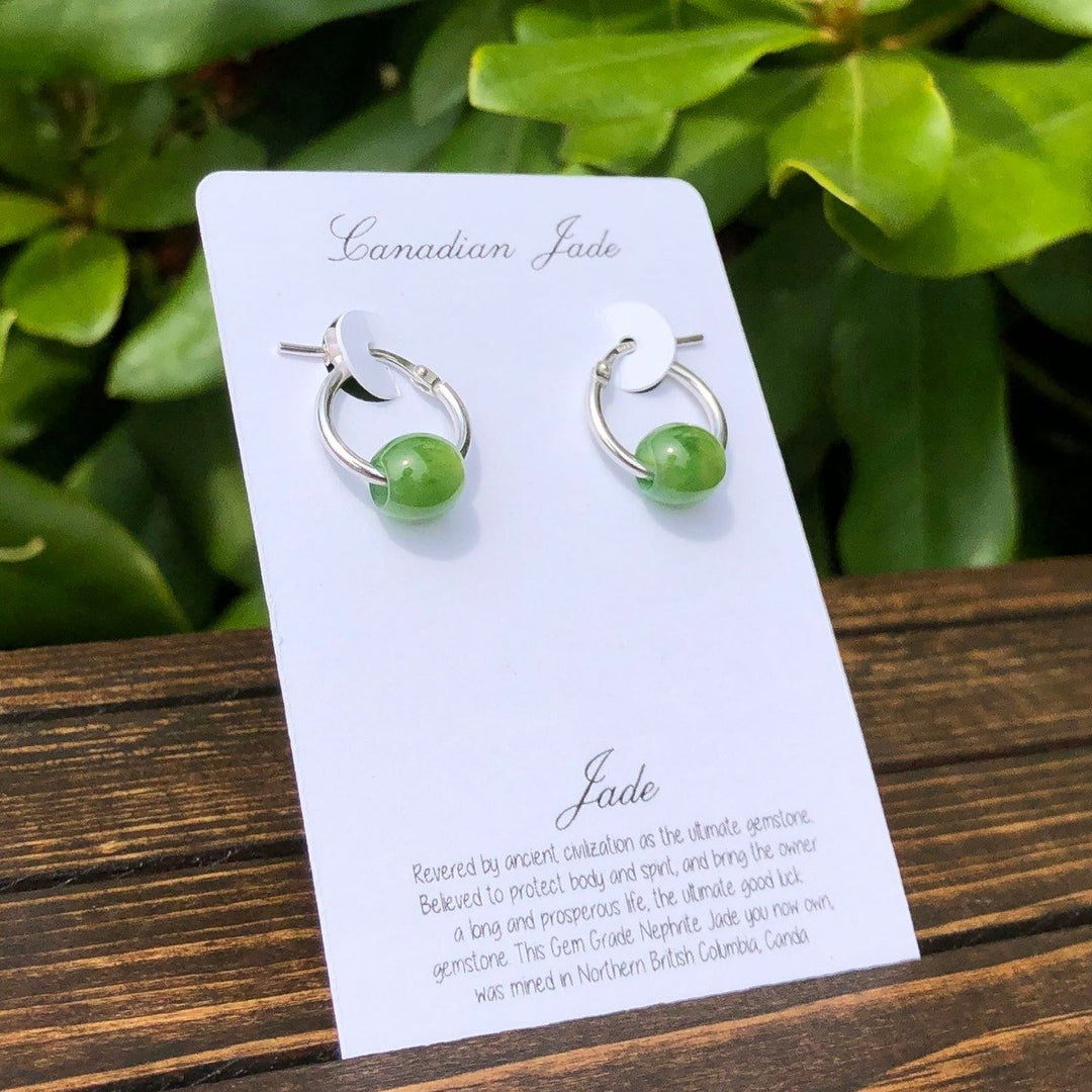 Green jade bead earrings on sterling silver hoops displayed on a white card