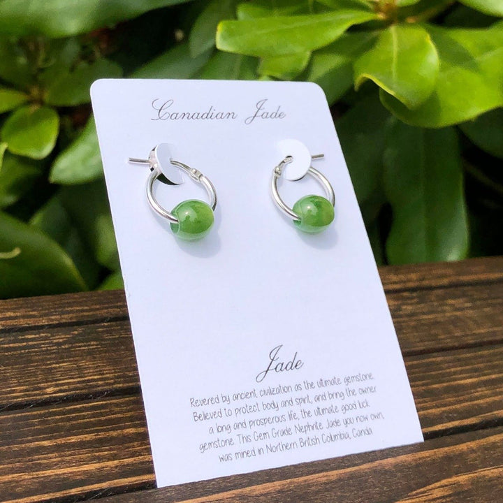 Green jade bead earrings on sterling silver hoops displayed on a white card