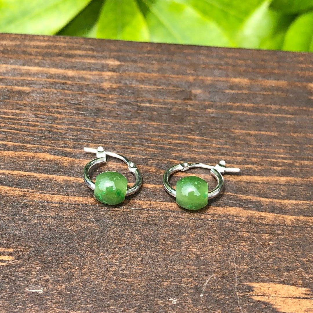 Jade bead hoop earrings on sterling silver hoops resting on a wooden surface