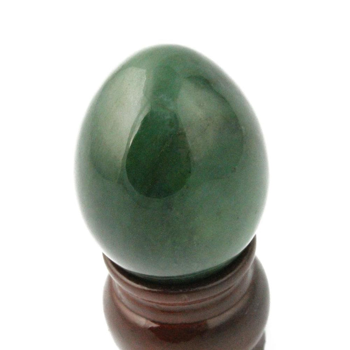 Dark green egg perched on a wooden display stand.