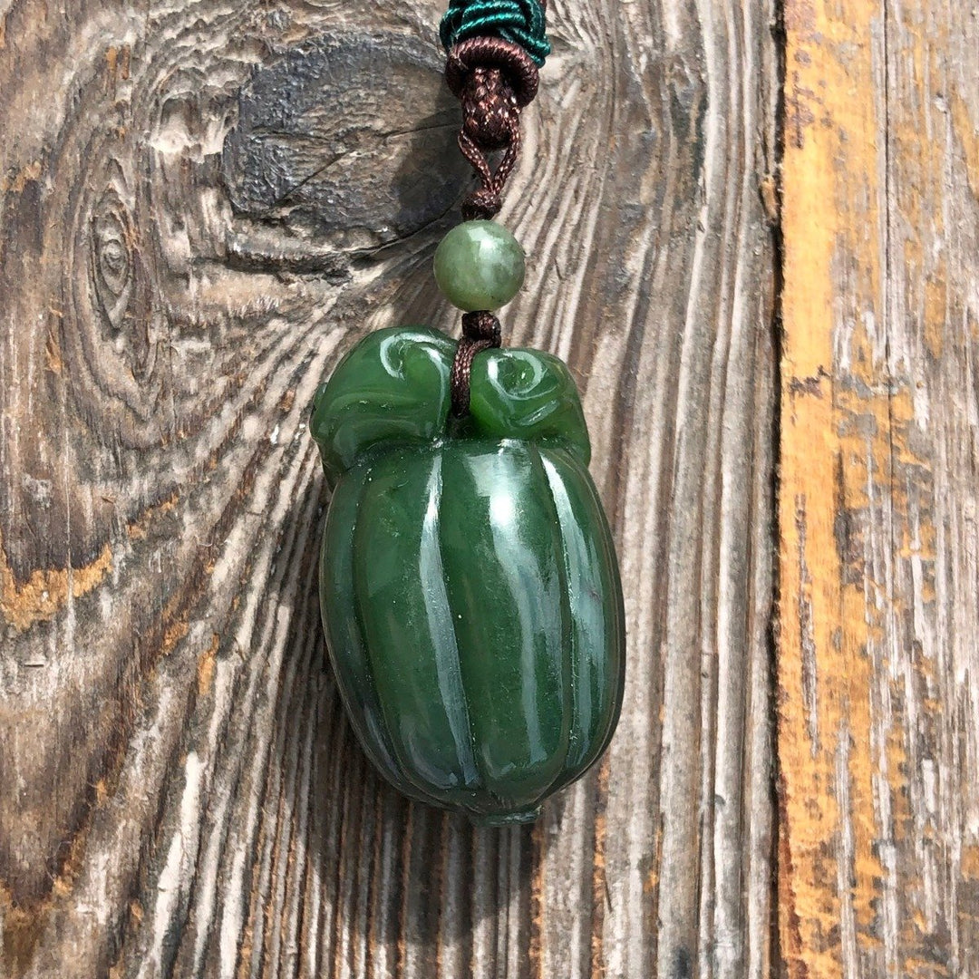Close-up of jade squash pendant 35mm on braided cord with a small green bead above.