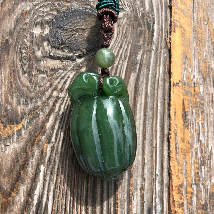 Close-up of jade squash pendant 35mm on braided cord with a small green bead above.