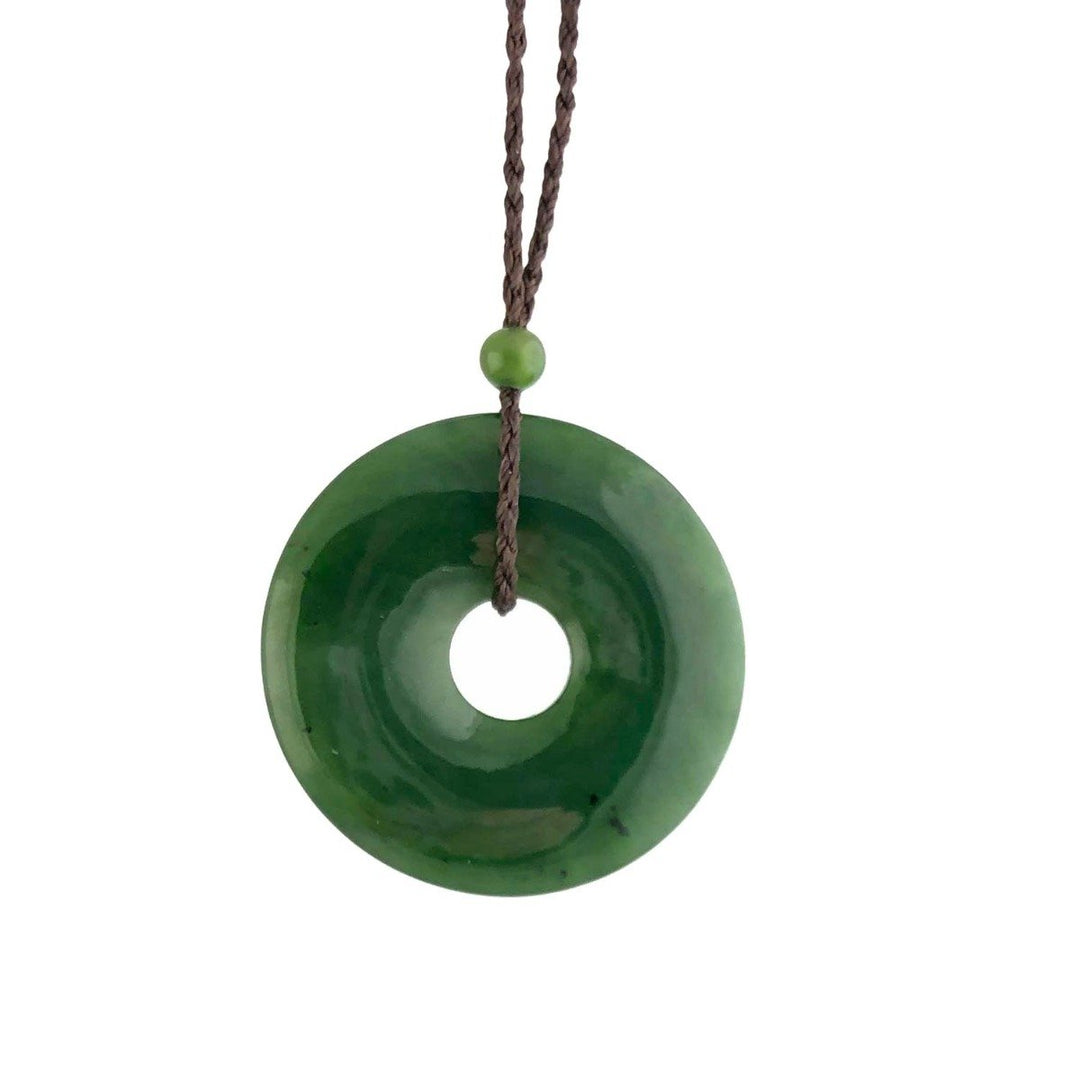 Dark green jade donut pendant on a brown braided cord with a small green bead