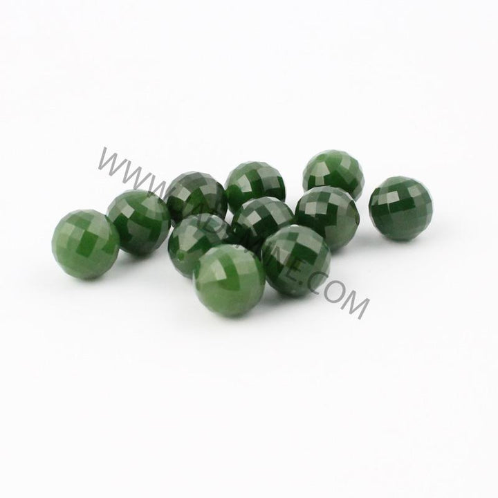 Group of 12mm faceted green beads spread on white background
