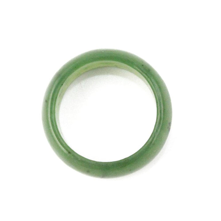 Green jade wide band ring on white background.