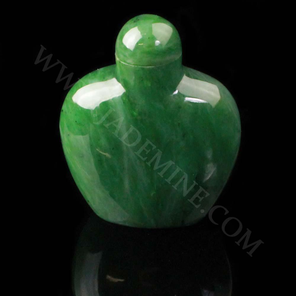Green jade perfume bottle with a rounded body and small dome cap on a black background.